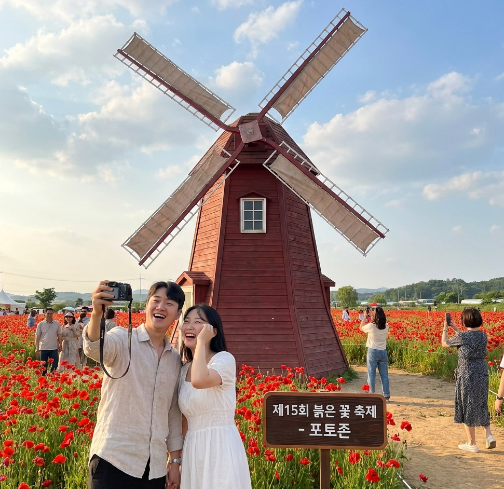 국적인 빨간 풍차와 그 앞에서 사진