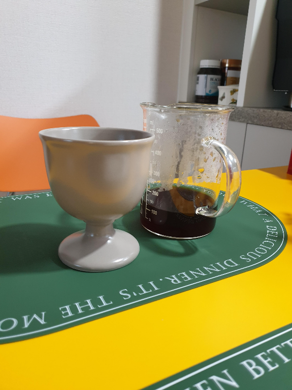 테이블 위에 추출된 커피와 빈 잔이 놓여있다.