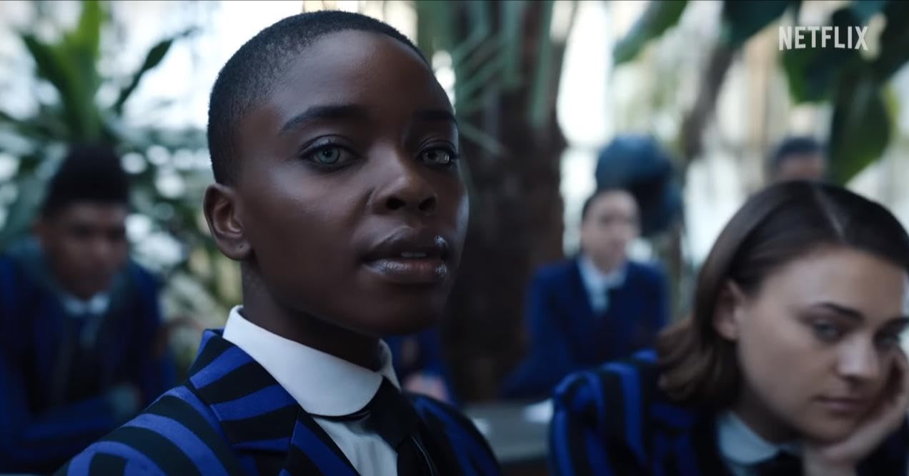 넷플릭스 웬즈데이 시즌2 캐릭터 비앙카 바클레이 역의 브랜디 제인 &ndash; 네버모어 아카데미 교복을 입고 교실에서 정면을 응시하는 장면
