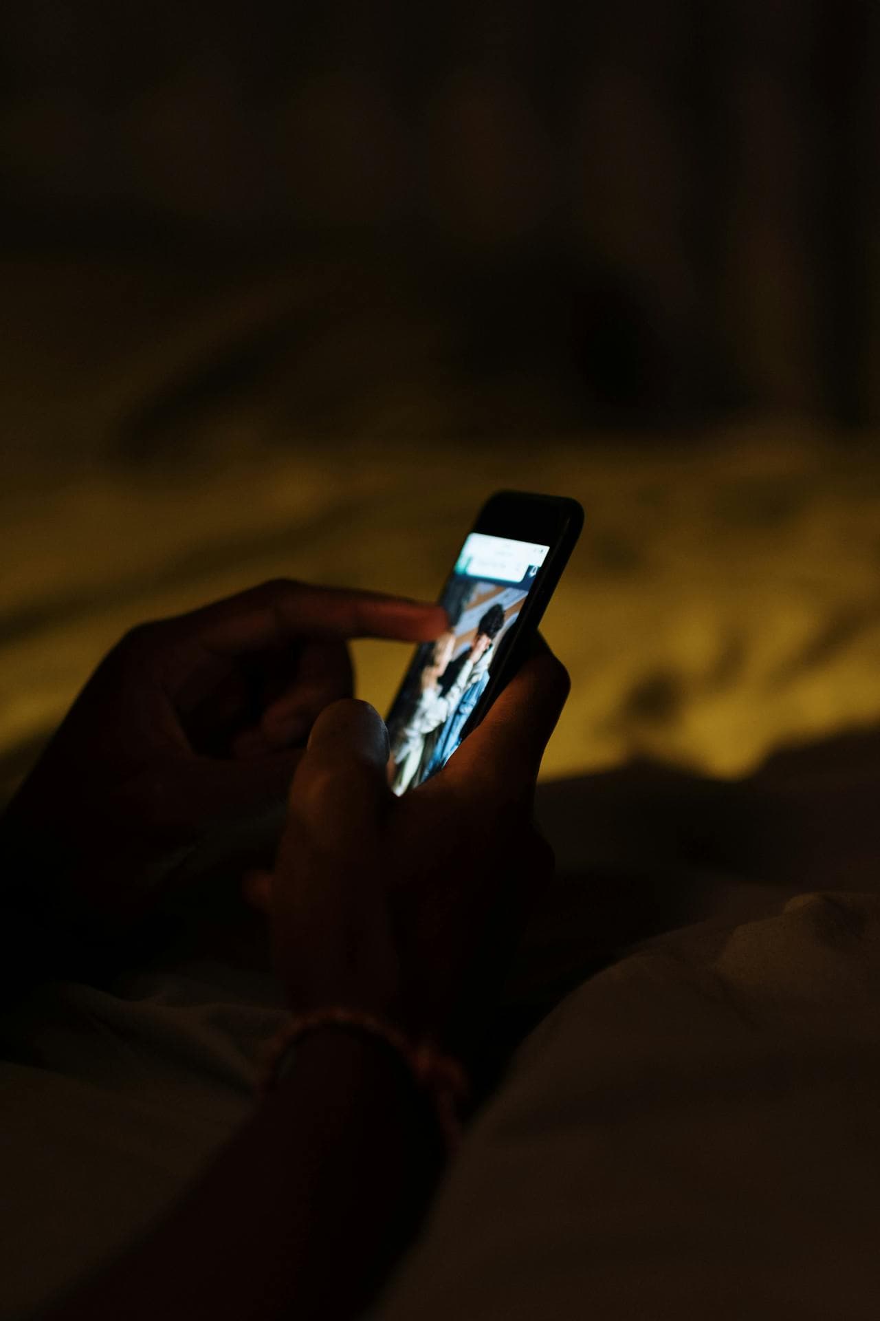 어둠 속에서 켜진 스마트폰을 쥔 손