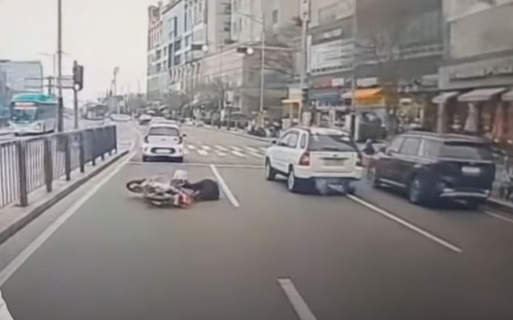 차로를 변경하던 차를 피하려다 도로에 쓰러진 오토바이 운전자를 두고 누리꾼들의 비판이 쏟아지고 있다. 사진은 지난 6일 오전 9시쯤 경기도 화성시 삼성1로 한 도로에서 2차로를 달리던 중 '비접촉 사고'를 겪은 오토바이 운전자. [사진=유튜브 '한문철 TV']