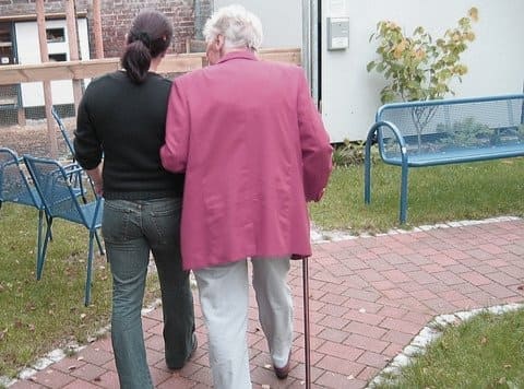 지팡이 든 노인과 함께 걷는 여성