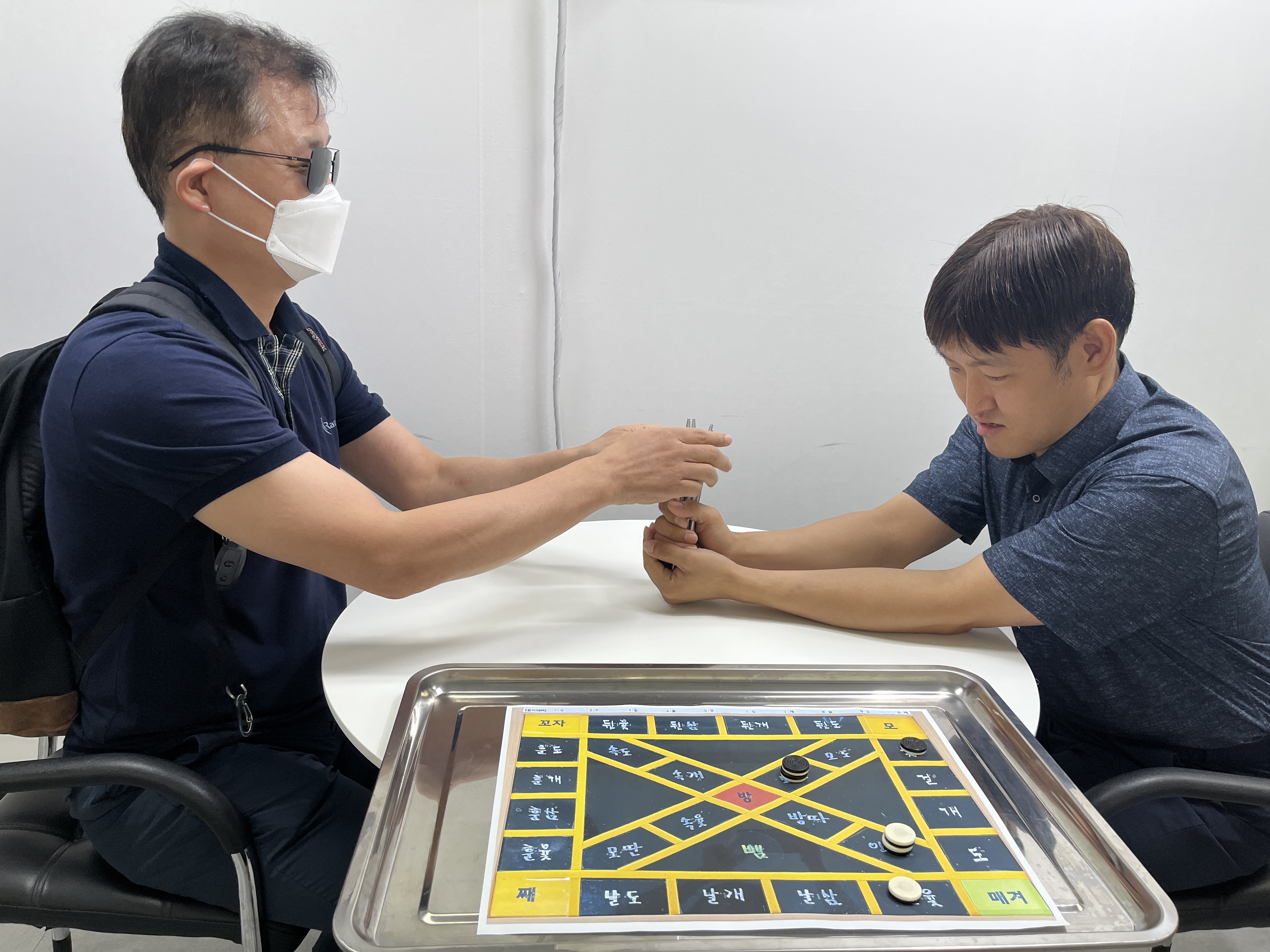 이미지 설명: 1부 윷놀이 경기사진. 김승만 지회원과 하현욱 지회원이 경기중임.