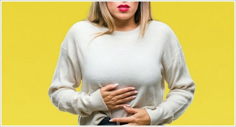 배탈로 인해 배를 잡고 있는 여성