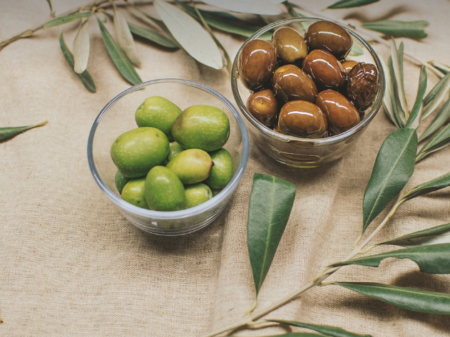 싱싱한 올리브와 숙성된 올리브가 유리그릇에 담겨 있다