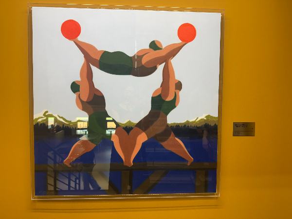 전시장 벽에 걸린 Life is a Circus 'My Superior' 그림. 네 명의 근육질 인물이 균형을 맞추고 있으며 빨간 공을 들어 올리고 있다.