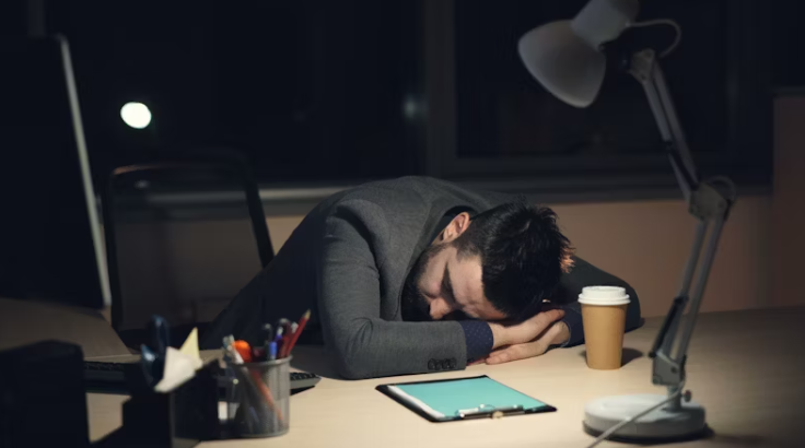 수면 부족으로 사무실 책상에 엎드려 잠든 직장인