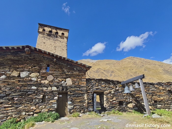 언덕에 있는 교회 내부. 코시키와 종이 있다.