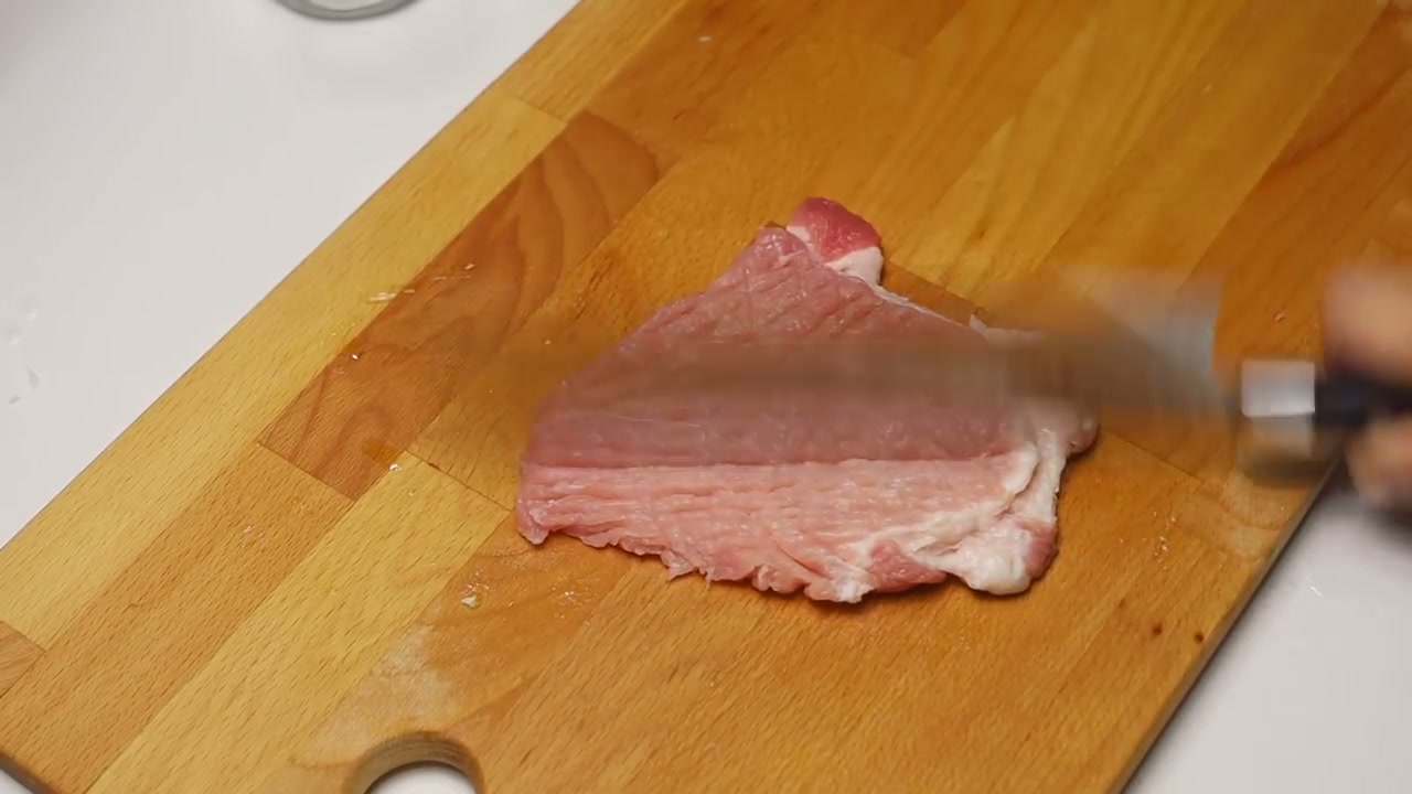 돼지고기 등심을 칼등으로 펴는 장면