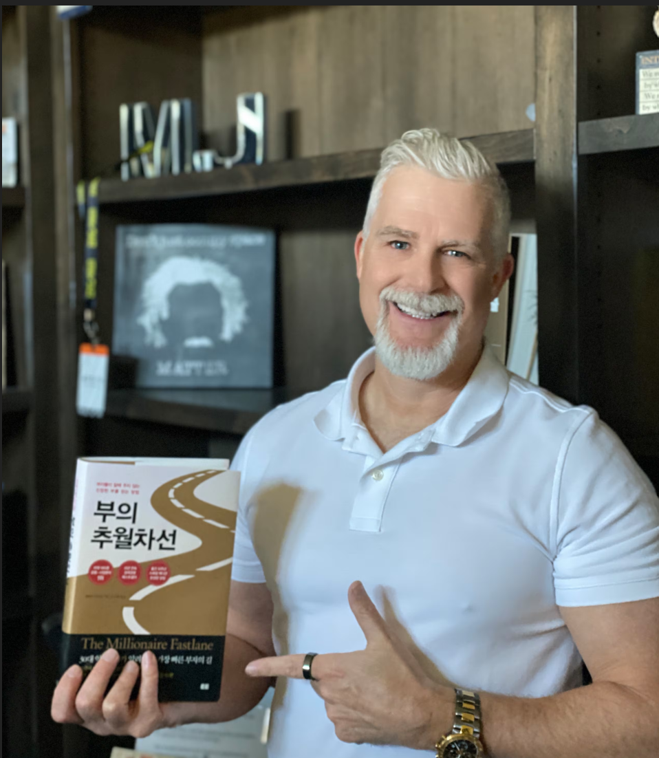 엠제이드마코가 한국어판 부의 추월차선 책을 들고 있는 모습