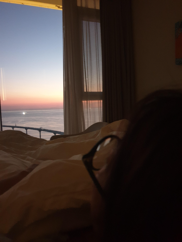 캄캄한 방안 창문 밖으로 해가 수면위로 떠오를 준비 중이다.