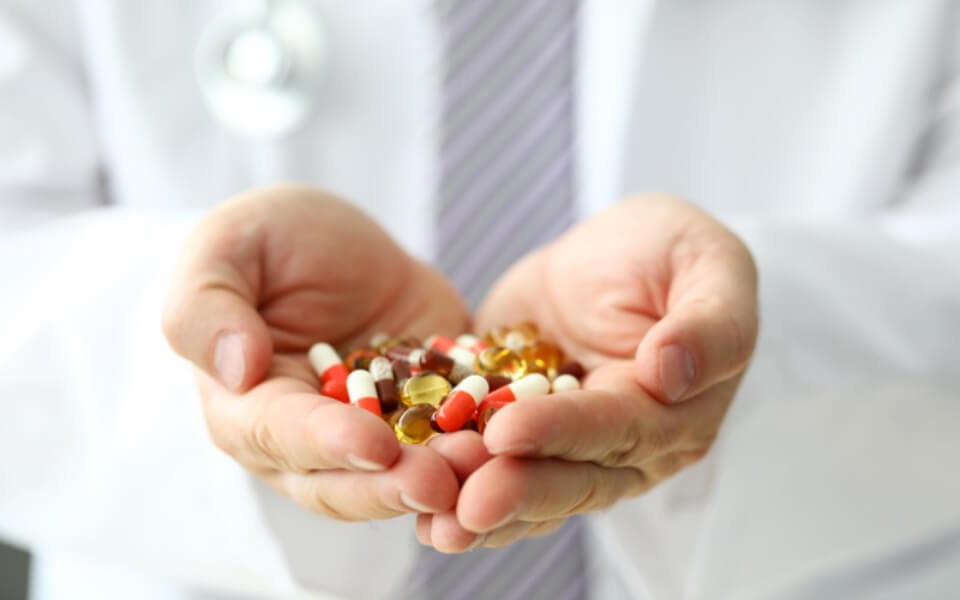 하트모양 손안에 여러가지 알약이 담겨있는 사진