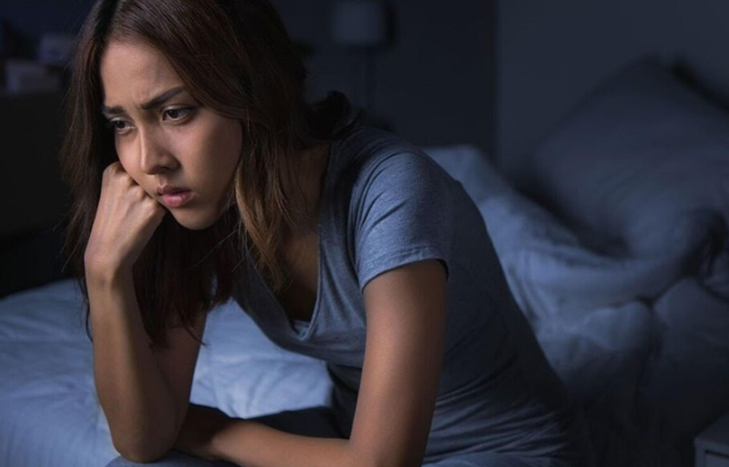 원인 모를 피로와 수면 부족으로 밤에 침대에서 고민하는 여성