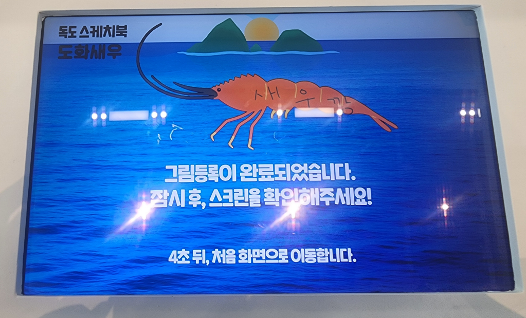 직접 색칠한 도화새우 그림이 등록 완료되어 대형 스크린에 송출된 모습