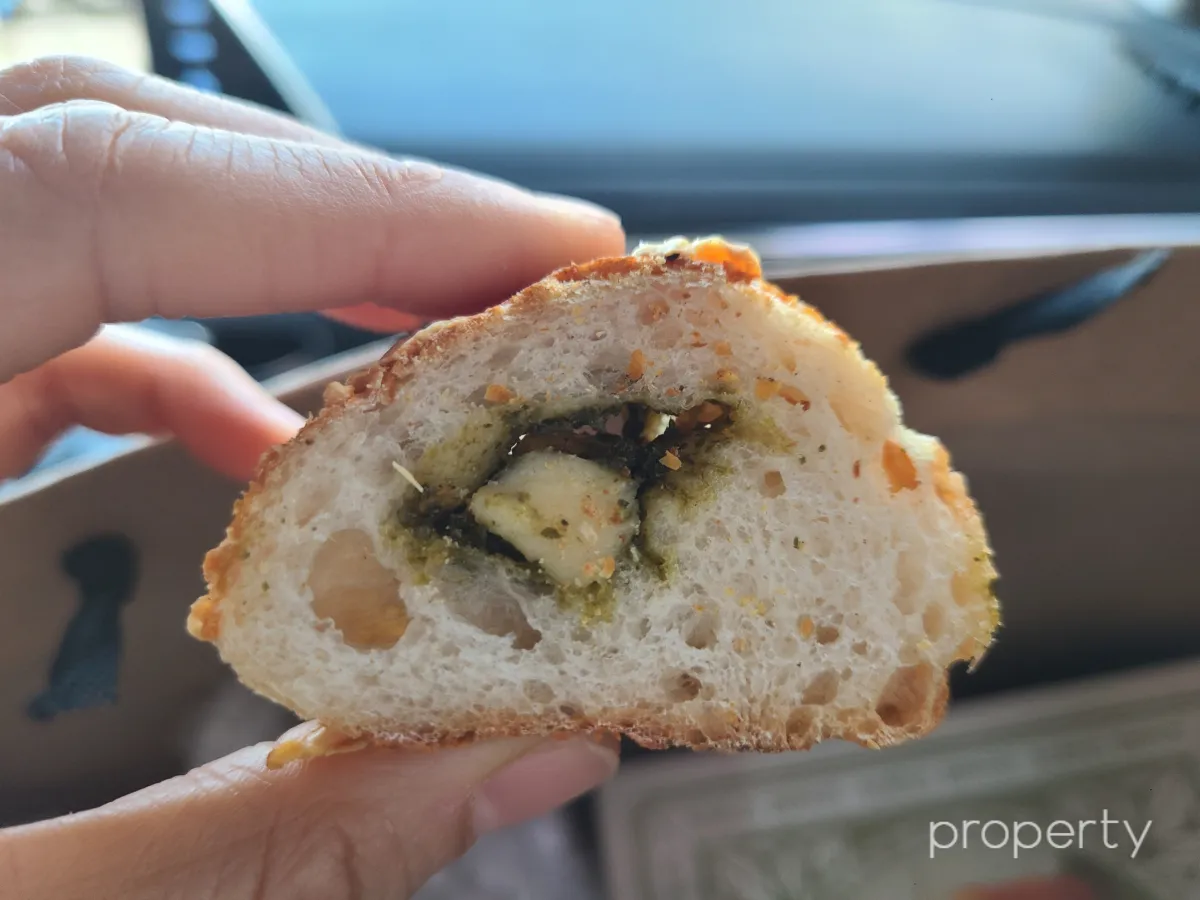 빵의-단면-안쪽에-바질에-둘러쌓인-치즈가-있다.