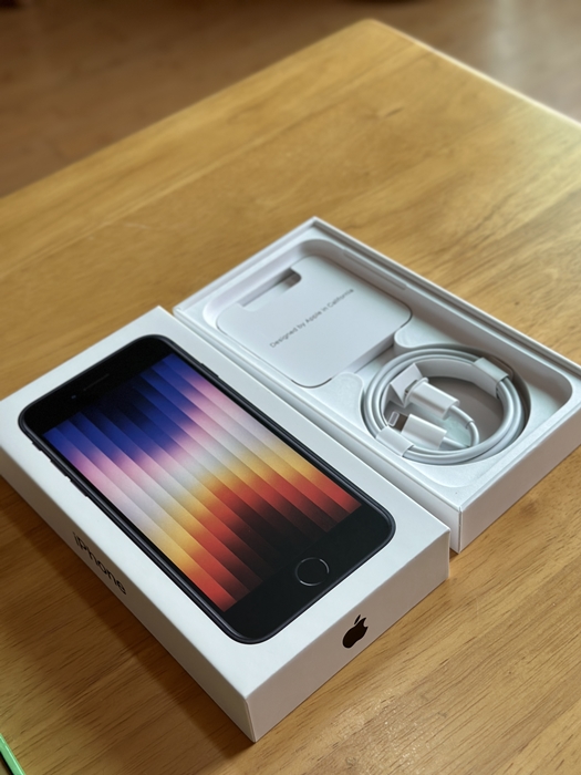 아이폰 SE3 박스를 열어 본체 전면과 함께 라이트닝 케이블 및 간단한 구성품이 보이는 모습