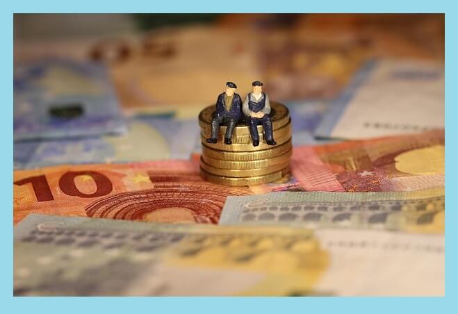 지폐-위-동전-앉아있는-사람