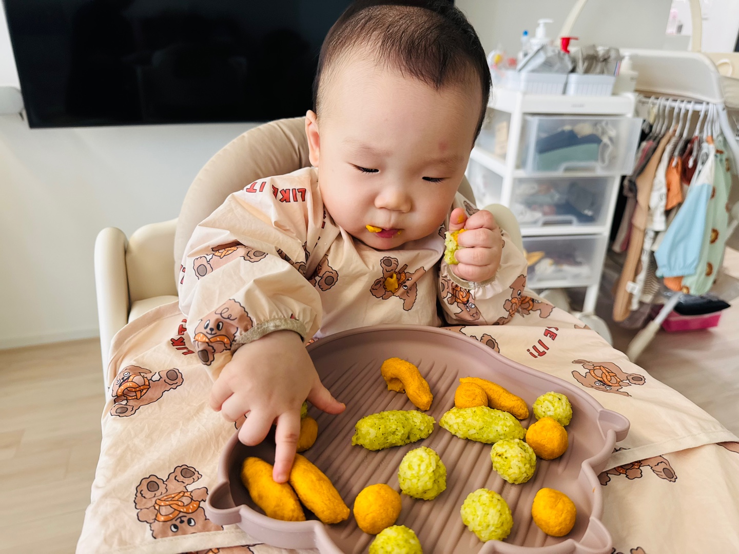 다양한 색깔의 밥스틱과 매시스틱을 앞에 두고 손으로 집으려는 찬솔이