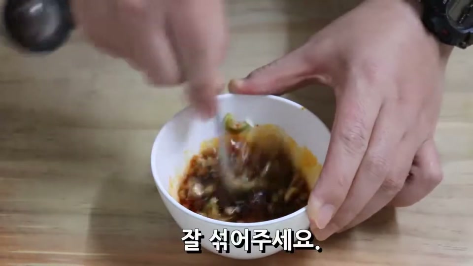 그릇에 양념을 넣고 섞는 장면