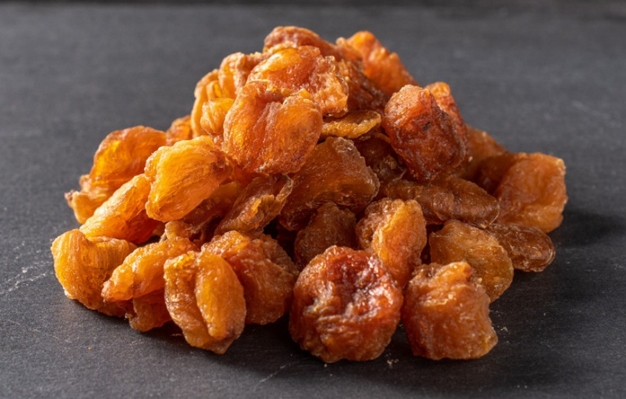 야생에서 채취를 한 용안육 열매의 껍질을 까고&#44; 씨를 빼낸 후에 바싹 말린 용안육을 짙은 회색의 바닥에 수북하게 쌓아놓고 확대하여 찍은 사진