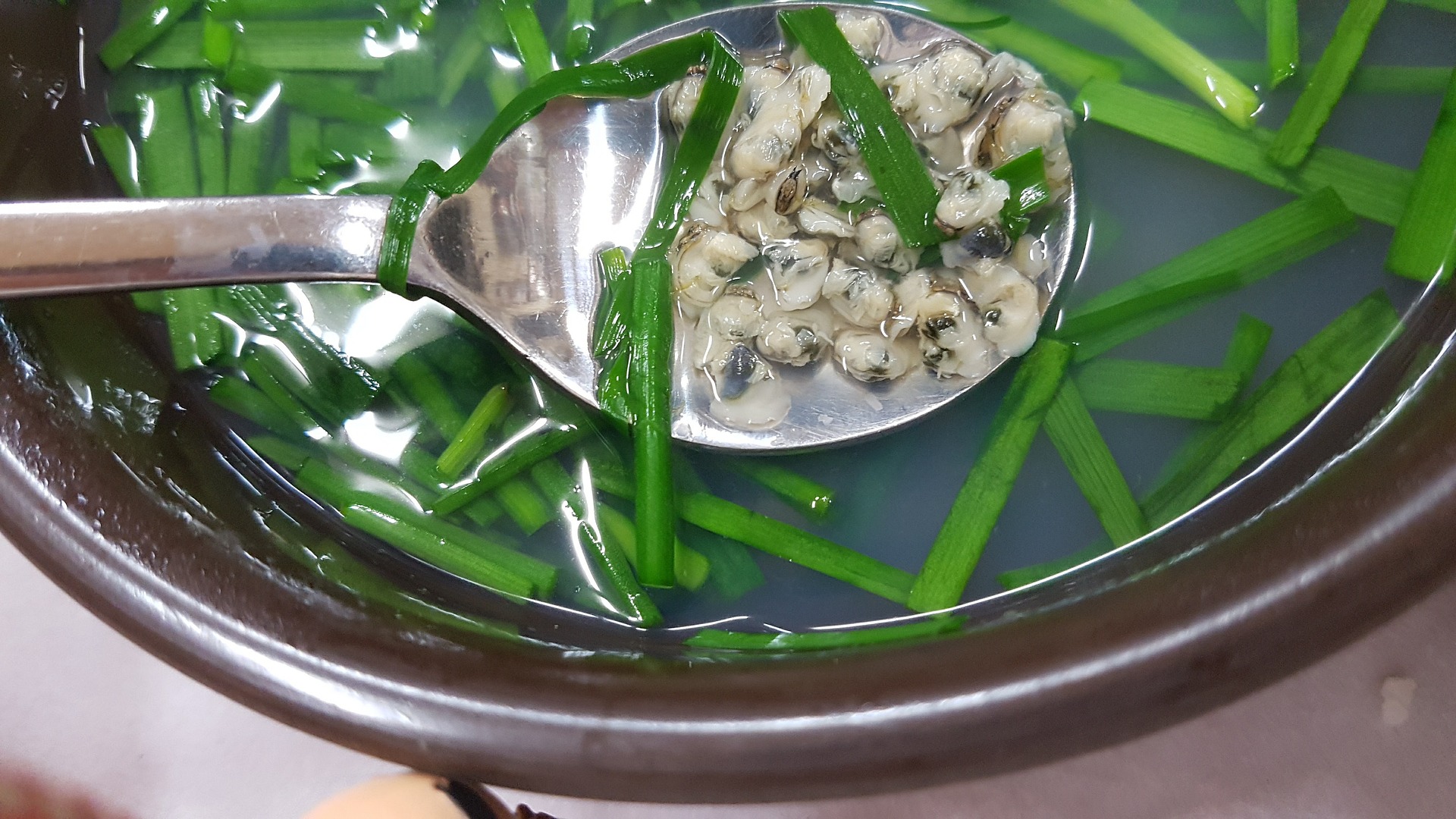 바다에서 채취를 한 재첩을 껍질을 까서, 잘 세척한 후에 뚝배기에 넣고, 부추와 육수를 붓고 잘 끓인 재첩국 사진
