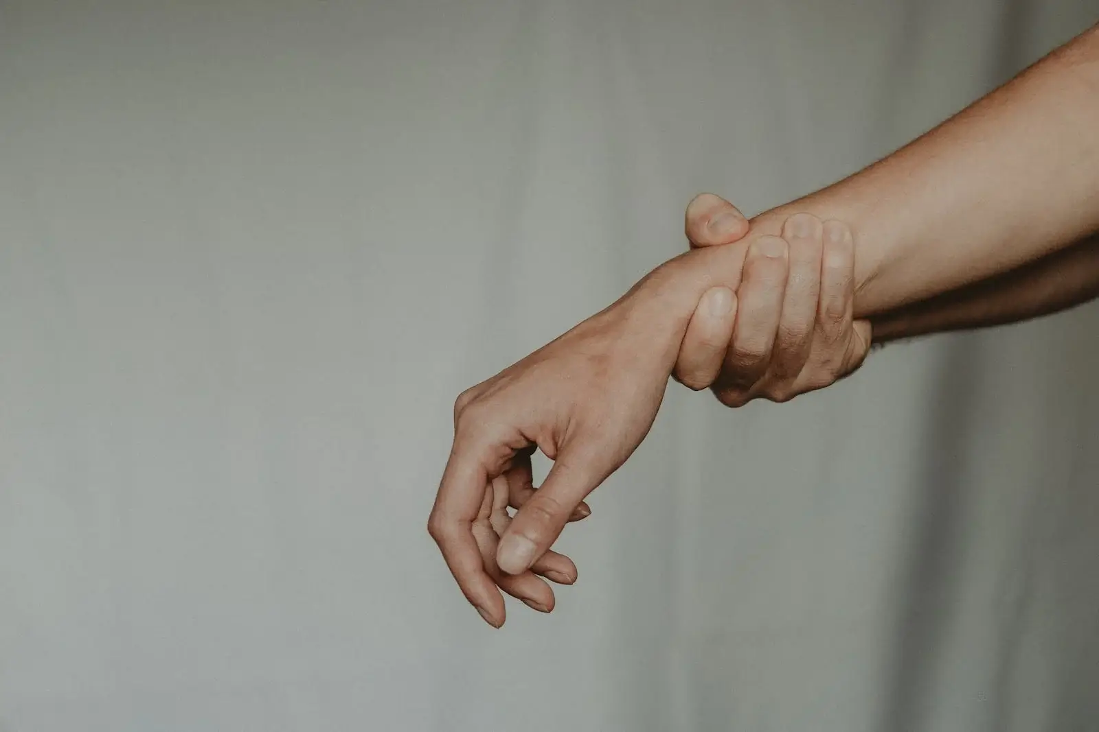 손목 통증으로 손목을 부여잡고 있는 사진