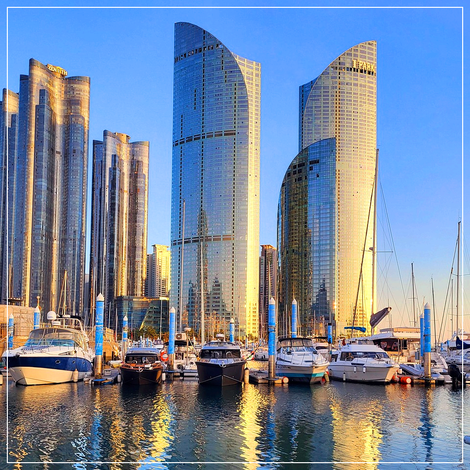 부산 해변의 고층 빌딩과 바다의 요트들