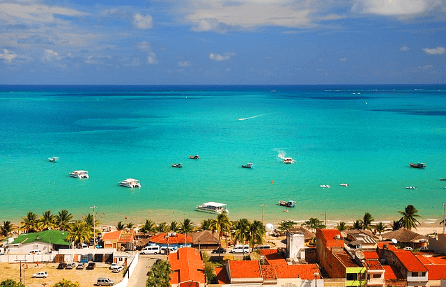 아름다운 청록색 바다가 있고 바다에는 배들이 떠 있는 이국적인 바닥사마을 풍경이다.