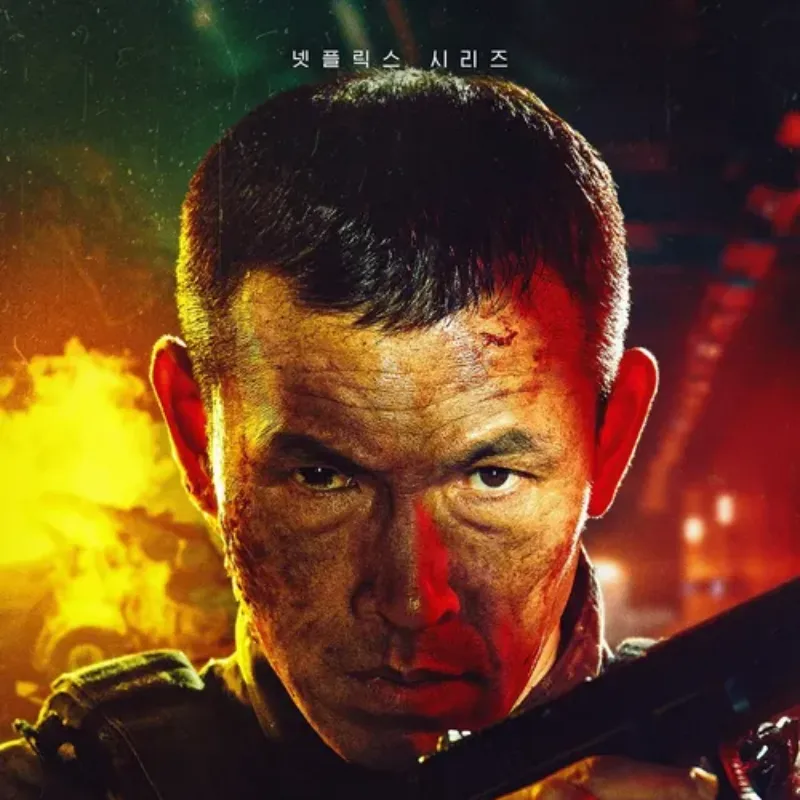 화염을 배경으로 짧은 머리에 군복을 입고 총을 들고 서 있는 스위트홈 시즌2에서 탁인환을 맡은 배우 유오성