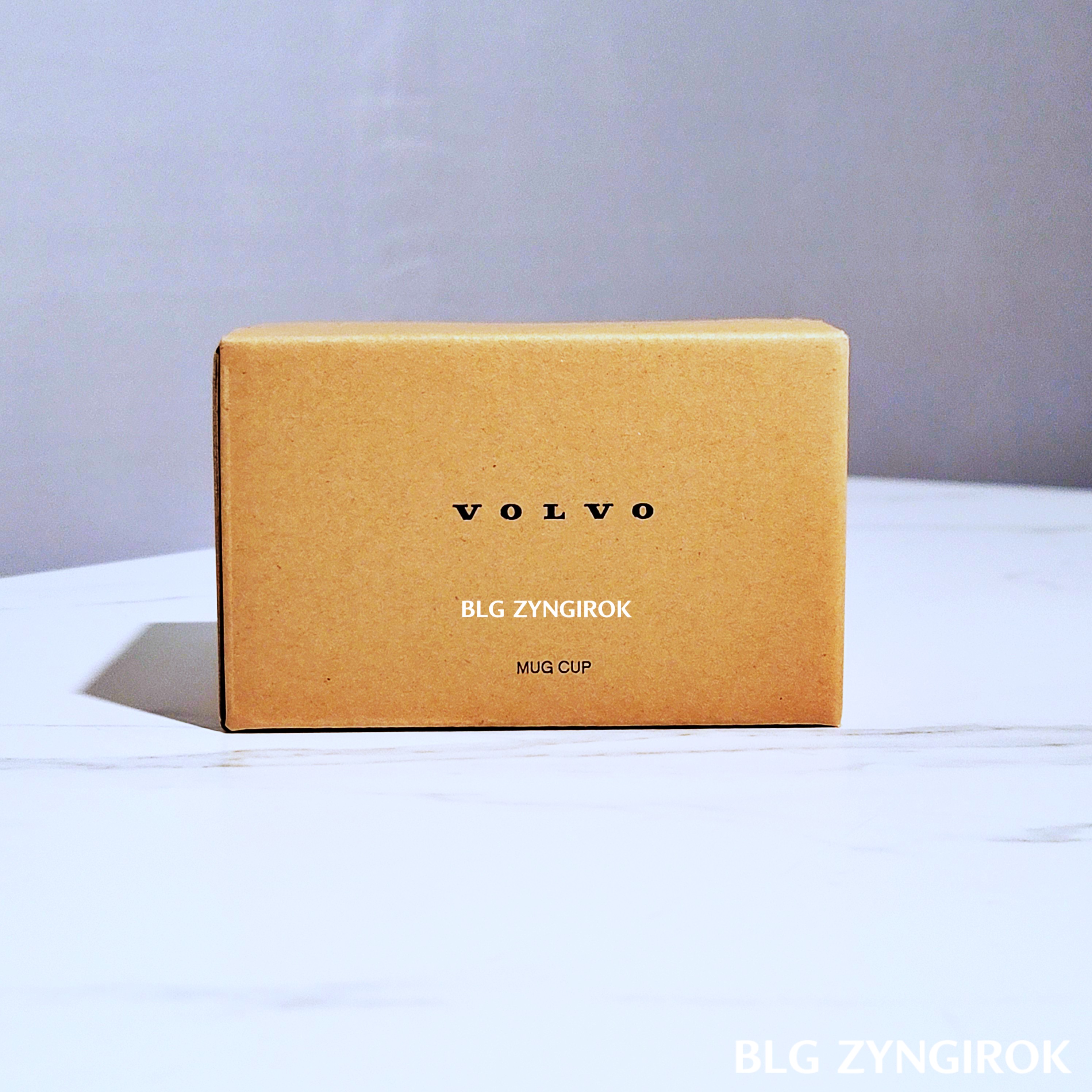 볼보 머그컵 상자가 테이블 위에 놓여있다. 상자는 크라프트지 재질이다.