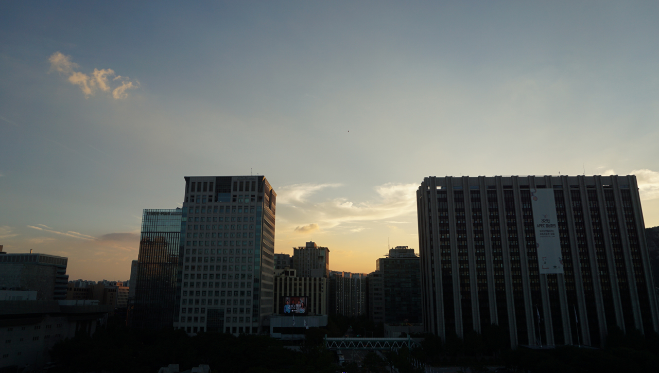 빌딩 사이로 금빛 노을이 지고 있다