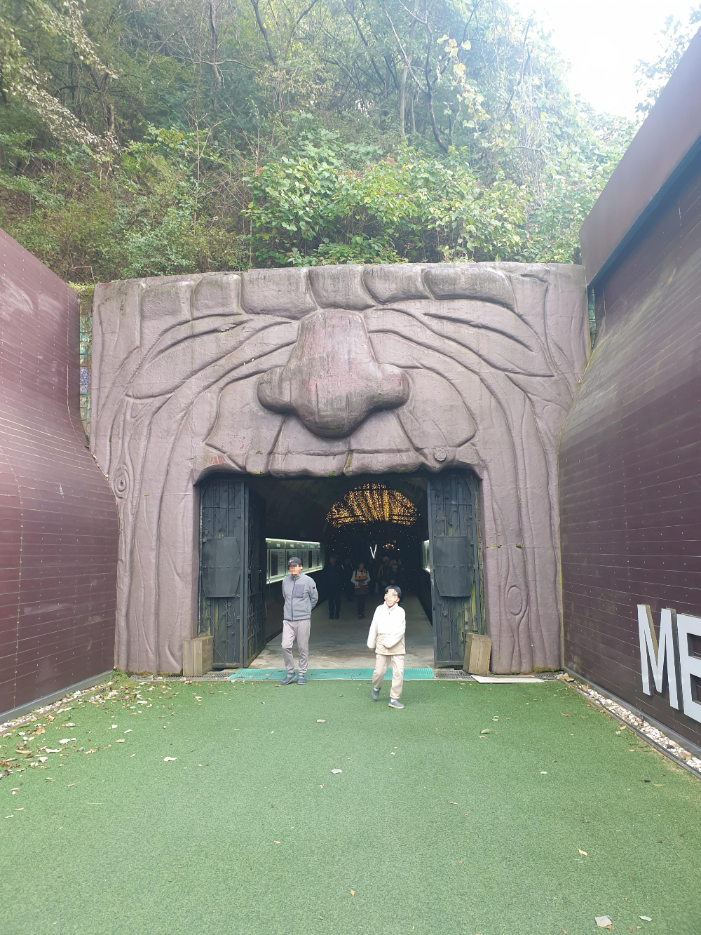 입을 벌리고 있는 동굴 입구. 안쪽 조명이 보인다.