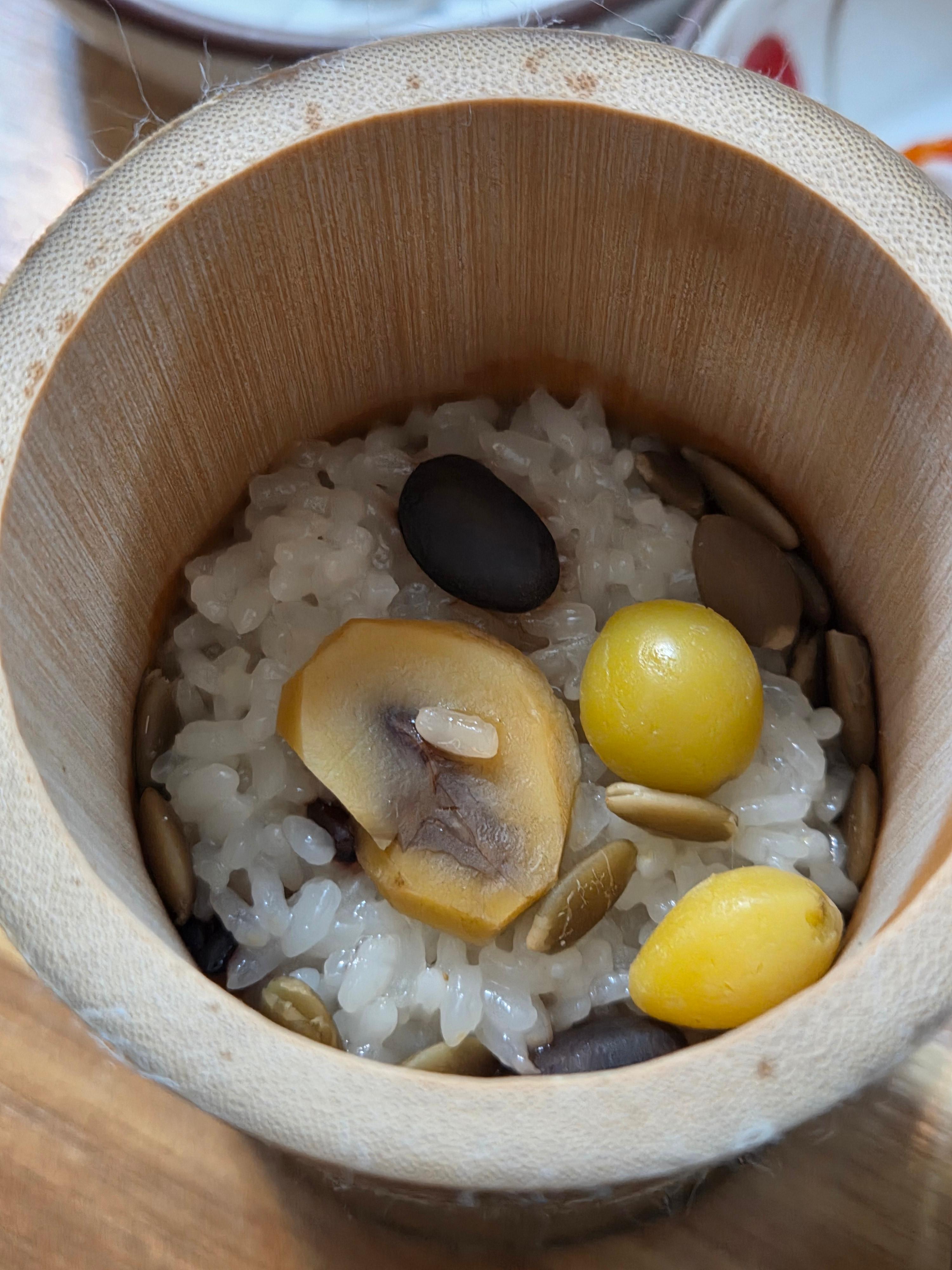 신식당 죽통밥 대나무 통에 담긴 밥 위로 은행 밤 검정콩이 올려져 있는 모습