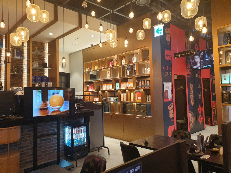 천장 조명과 함께 벽에 있는 술병들이 눈길을 끈다.