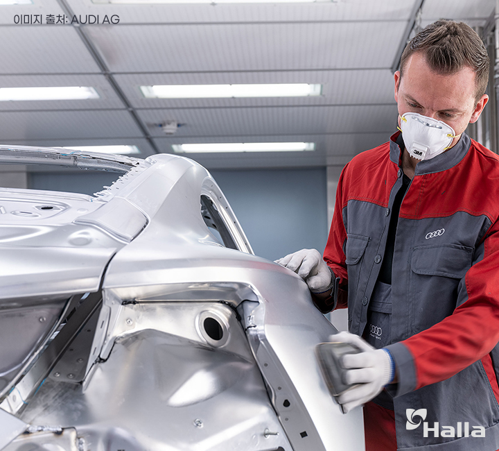 아우디 노동자가 자동차 본체를 연마질하고 있는 사진