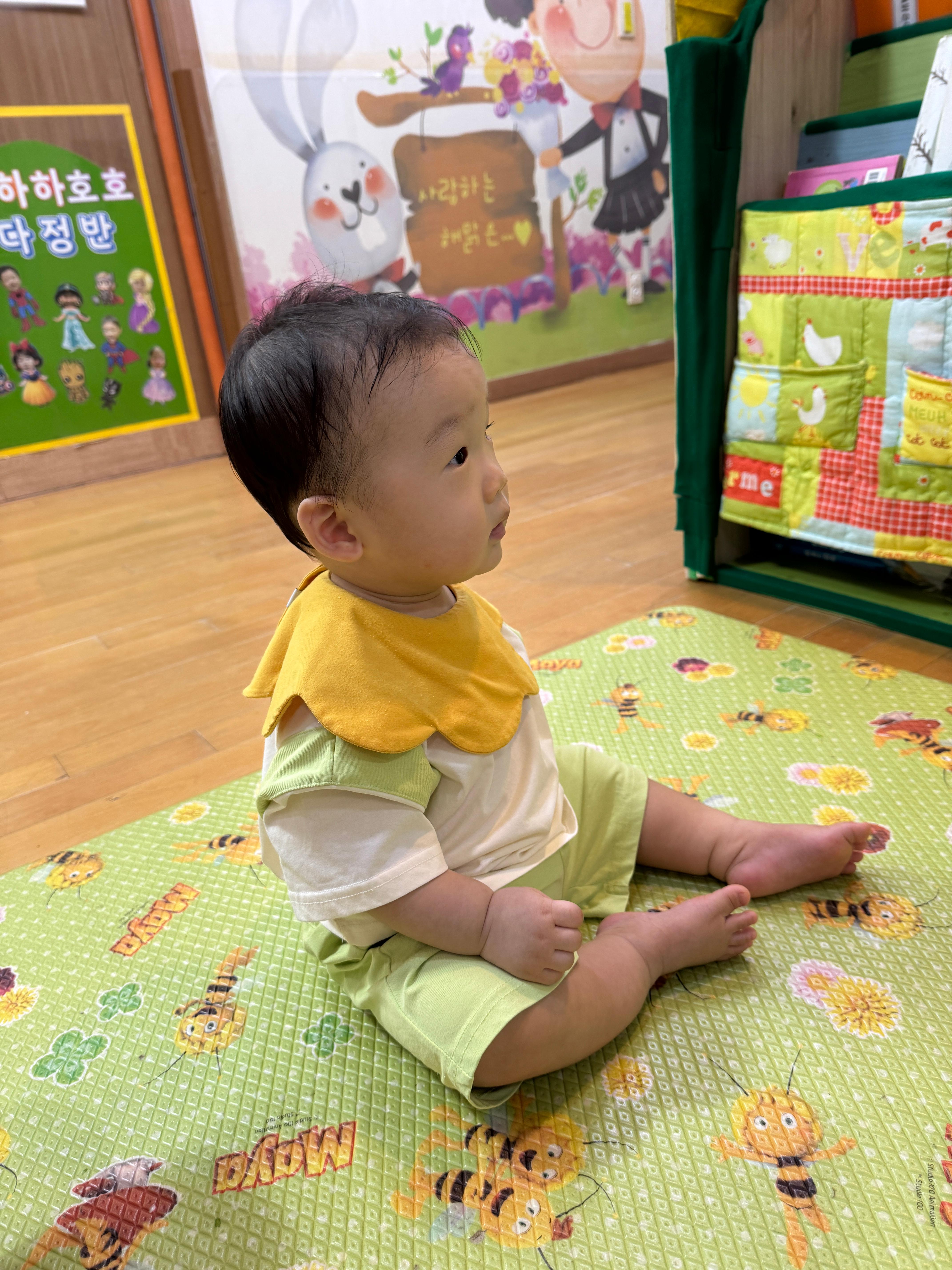 어린이집 첫 등원한 11개월 아기가 원장님 바라보고 있는 사진