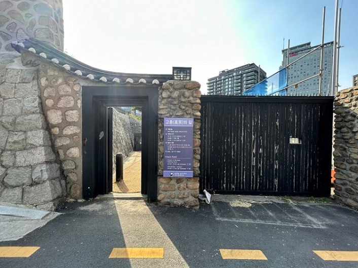 돌담과-철제문으로-이루어진-출입구를-찍은-사진