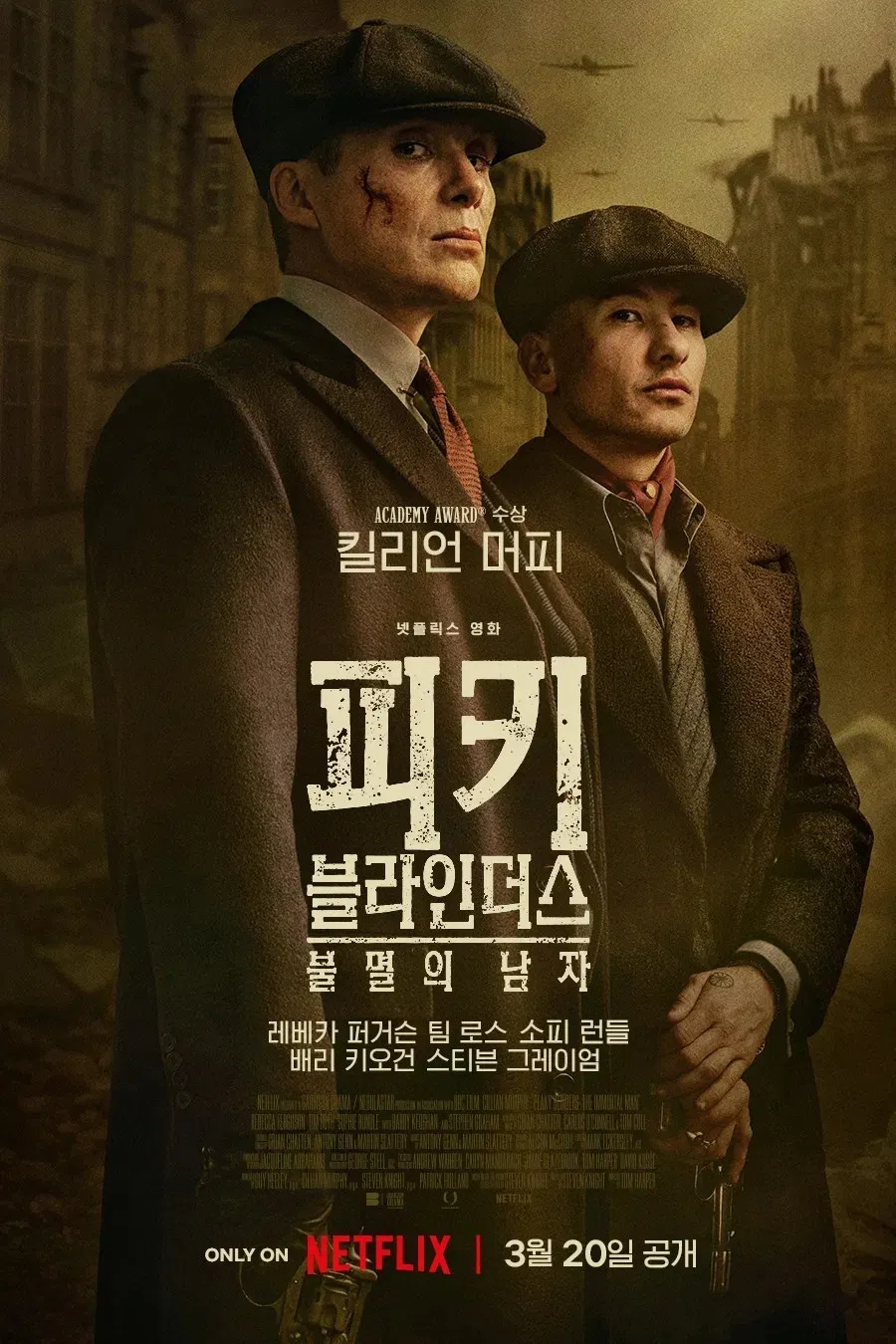 영화 피키 블라인더스: 불멸의 남자 포스터, 두 남성이 어두운 도시 배경 속에서 서 있는 메인 이미지
