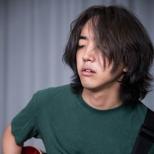 이승윤-Honey-이승윤이-청록색-반팔-티를-입고-머리를-풀어헤치고-기타를-치는-사진