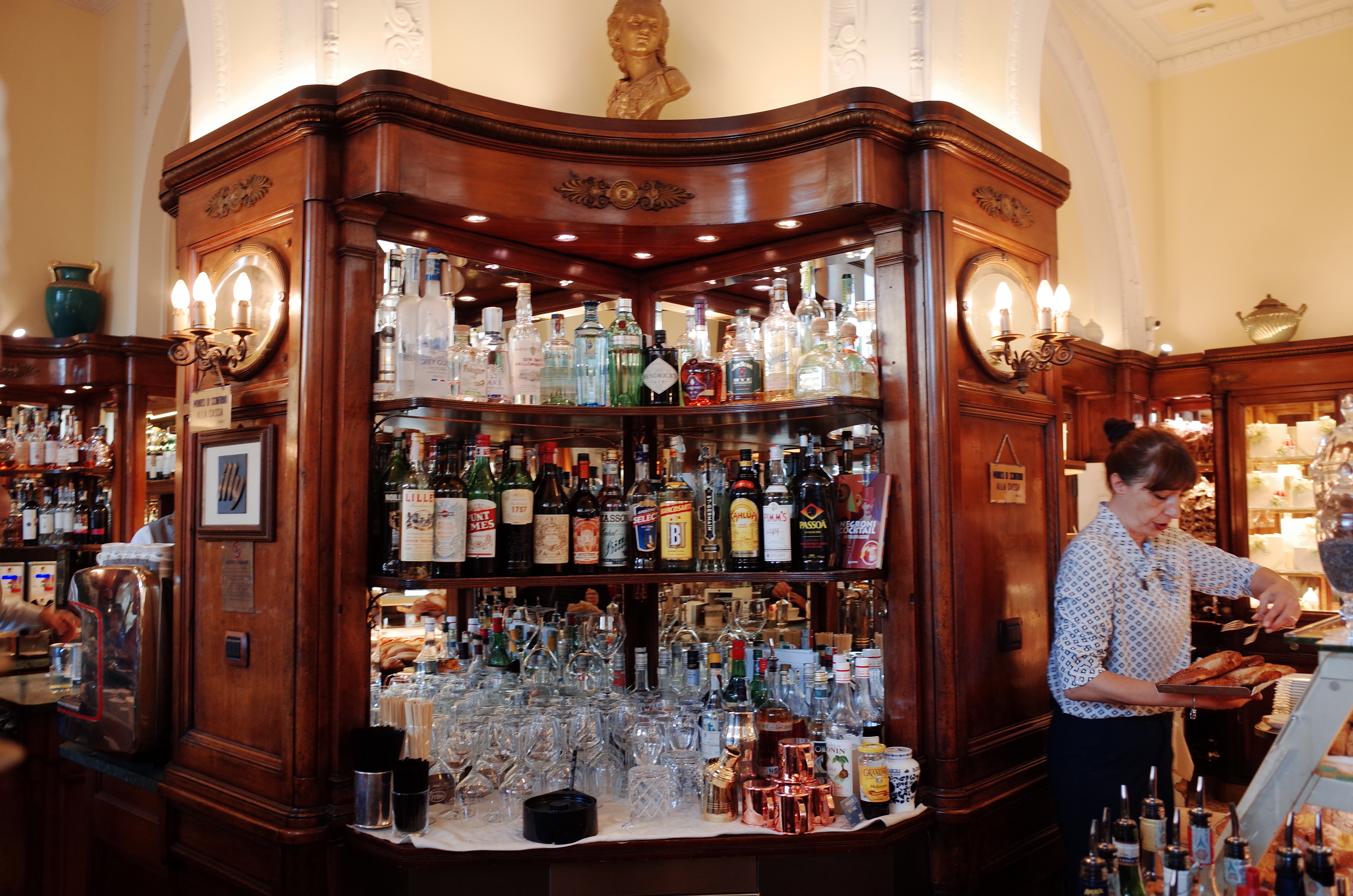 고급스러운 목재 장식과 다양한 주류가 진열된 피렌체의 전통 있는 카페 바 내부