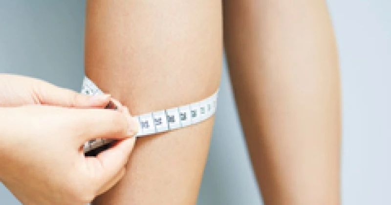 종아리 둘레를 재고 있는 여성