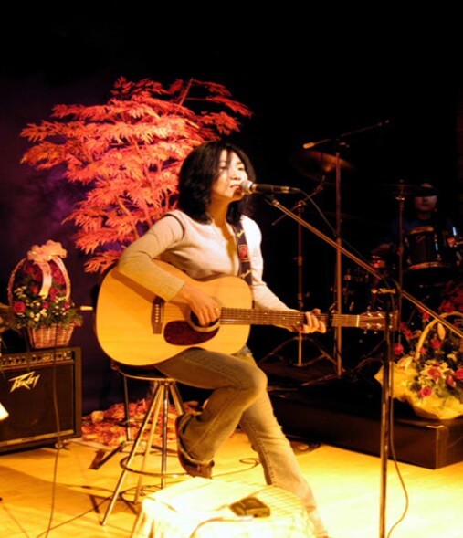 박강수-바로-나-박강수가-무대위-의자에-앉아-기타를-치며-노래를-부르는-사진