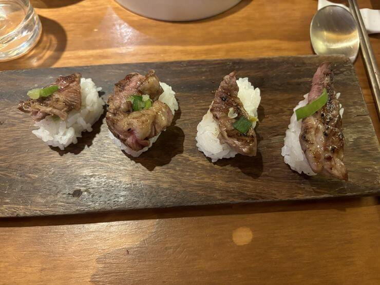 나무접시 위에 양등심초밥 4피스가 있다.