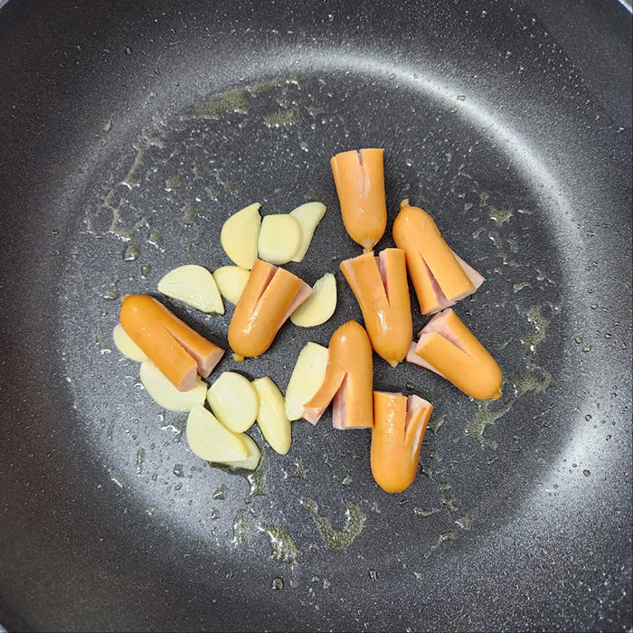 후라이팬 위에 있는 비엔나와 마늘