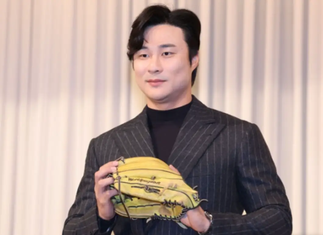 김하성-베이지색 커튼 앞 노란색 글러브를 낀채 검은 양복을 입고 포즈를 취하고 있는 김하성