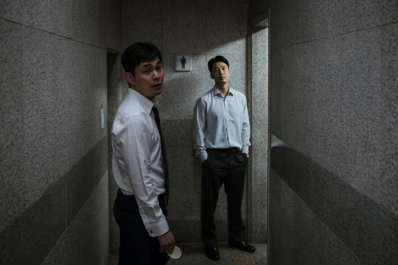 검찰에서 마약 혐의 소변검사를 위해 화장실 앞에 서있는 조훈의 모습