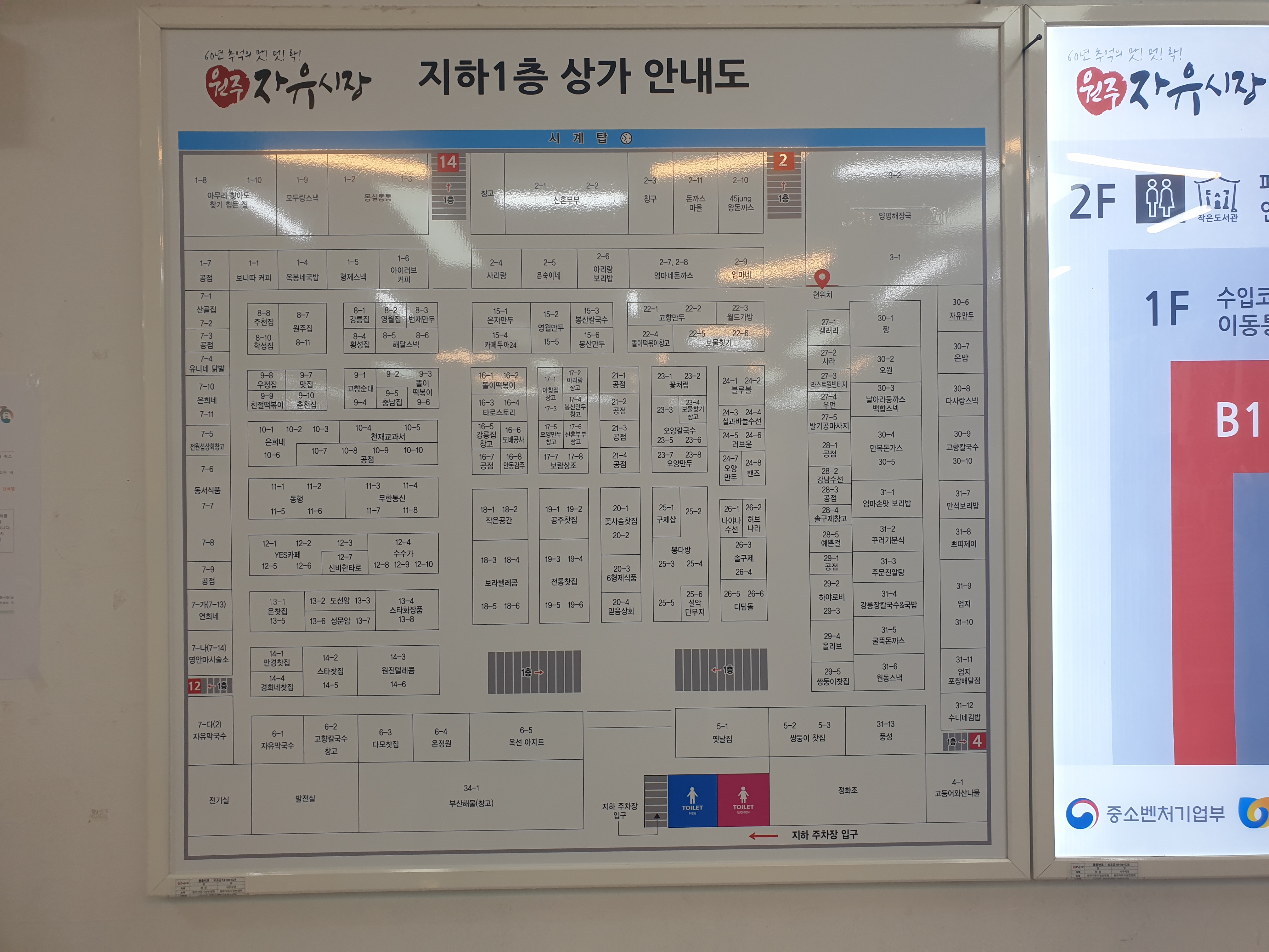 벽면에 큰 안내판이 붙어 있다. 1층 지하 상가 배치도.
