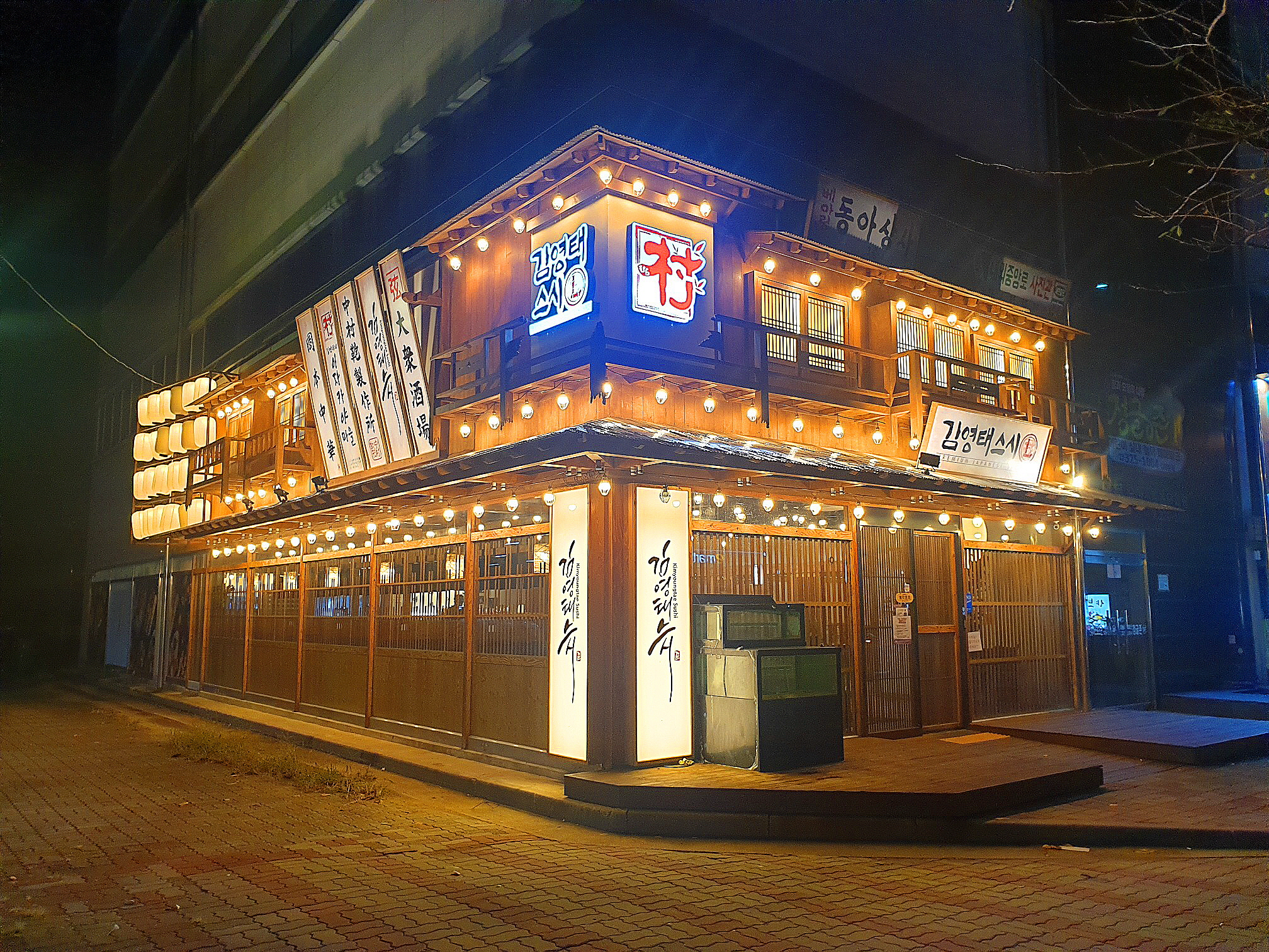 밤에 불이켜진 스시집 건물