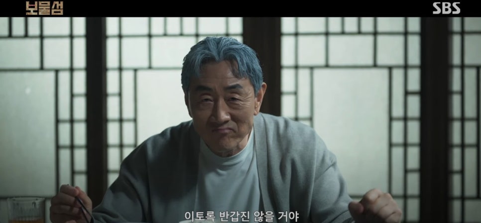 식사 자리에서 미소를 띤 채 말을 하는 노년의 남성.