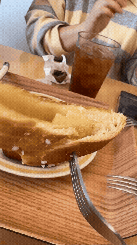 분당 미금역 카페 휴유의 핑크솔트 소금빵을 포크에 찍어서 보여주는 gif. 자른 소금빵 사이에 버터와 패스튜리 층이 보인다.